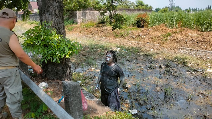 Salah satu manusia silver berupaya lari dengan masuk sungai saat dirazia Satpol PP Jombang