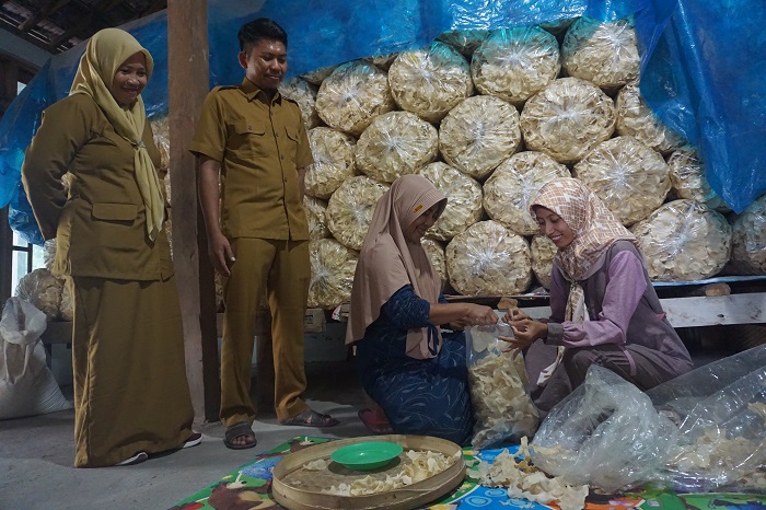 Kepala Desa Made Winarsih (paling kiri) meninjau proses pengemasan keripik gadung di salah satu rumah warga.