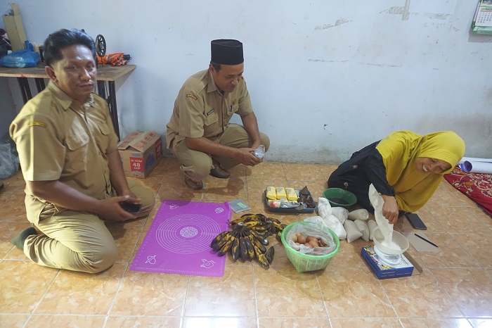 BIKIN KUE: Kades Ceweng Imam Subata (tengah) bersama perangkat desa meninjau salah satu warga yang tengah memproduksi kue, Senin (18/12)