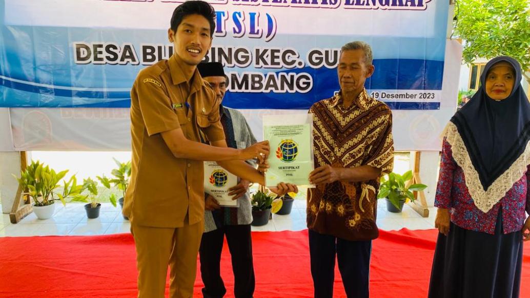 Kades Blimbing Wahyu Hidayat menyerahkan sertifikat PTSL kepada warganya, Selasa (19/12).