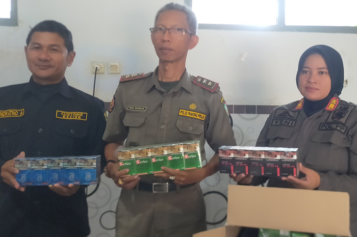 Petugas Kantor Bea Cukai kediri dan Satpol PP Jombang menunjukkan hasil razia rokok ilegal Selasa (19/12)