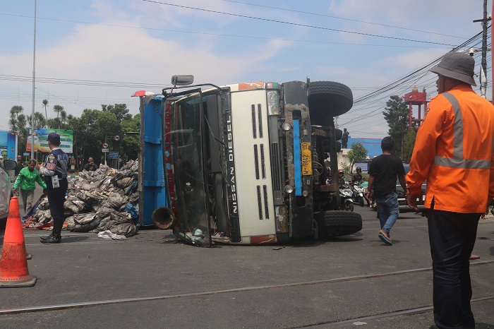 Truk muatan baru bara yang terguling di simpang rel KA Jombang menutup badan jalan. Untuk menghindari kemacetan, petugas melakukan pengalihan jalur.