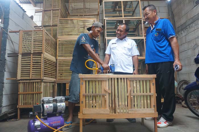 Kepala Desa Gempollegundi Sagiyan Taruna Alip (baju putih) melihat proses produksi kandang di salah satu gudang produksi warga yang mendapat bantuan alat kompresor.