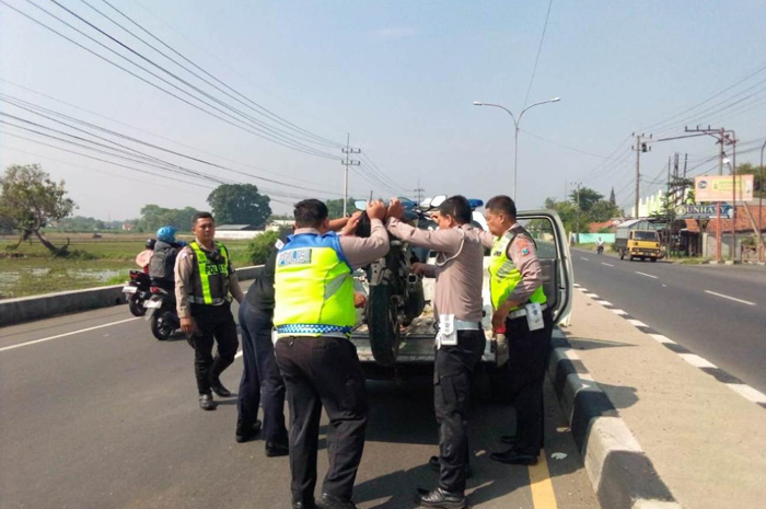 Petugas kepolisian saat mengevakuasi kendaraan korban tewas di Jalur Arteri Jombang