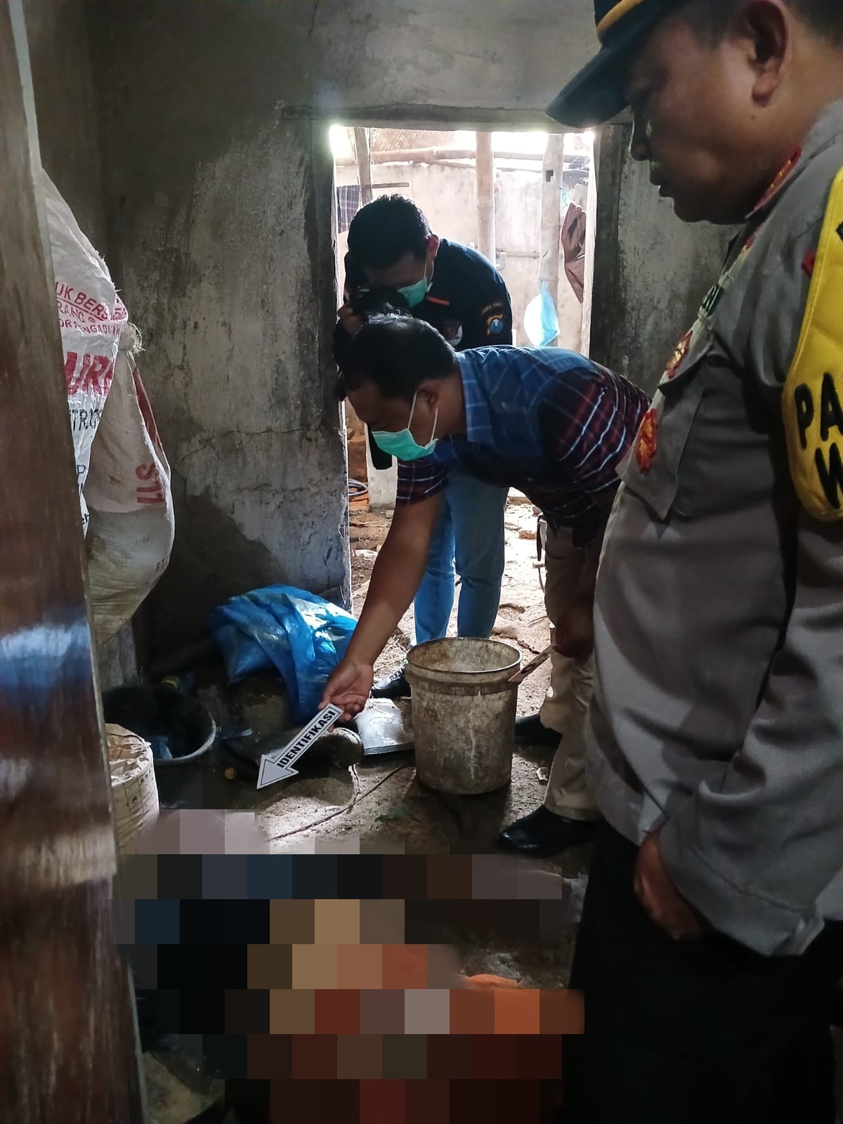 Petugas kepolisian saat melakukan identifikasi dan olah TKP di lokasi penemuan mayat di dapur sebuah rumah Desa Morosunggingan, Peterongan, Jombang