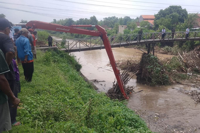 Sampah dan sangkrah yang menumpuk di tiang jembatan Kali Gunting di Desa Karobelah, Kecamatan Mojoagung, diangkat menggunakan alat berat, Rabu (3/1).