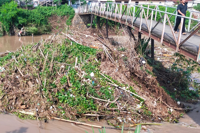 Sampah dan sangkrah menumpuk hingga tertahan di tiang jembatan Kali Gunting Desa Karobelah, Kecamatan Mojoagung, Rabu (3/1).