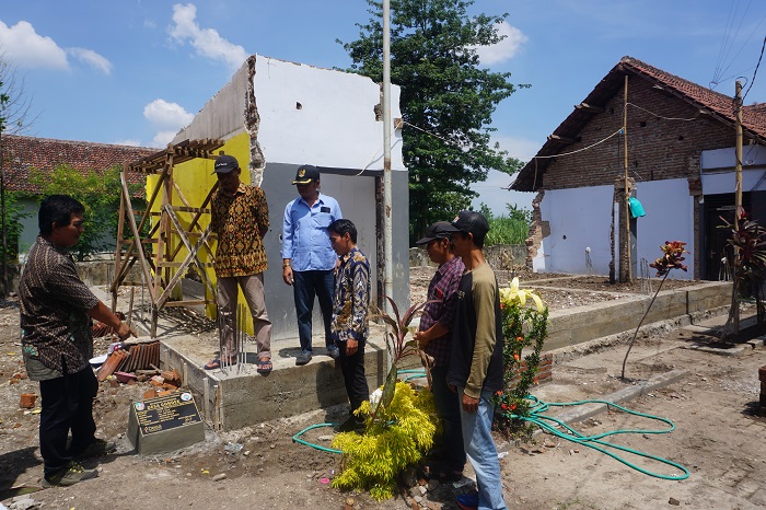 Kepala Desa Gondek Hisbulloh Huda (baju batik paling kiri) didampingi perangkat desa dan ketua TPK saat menunjukkan pembangunan kantor desa baru.