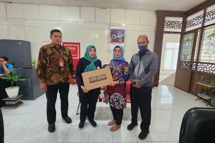 Pegawai Bank Jatim Cabang Jombang menyerahkan undian laptop kepada pemenang.
