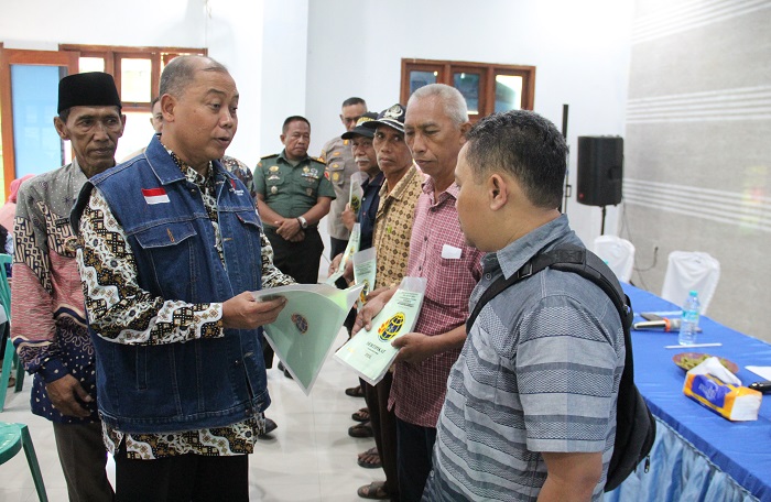 DIBAGIKAN: Pj Bupati Jombang Sugiat membagikan PTSL kepada warga, Kamis (11/1).