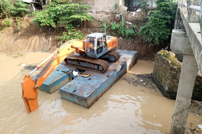 Sebuah alat berat diturunkan ke Kali gunting untuk perbaikan tanggul sungai yang terkikis  Rabu (10/1)