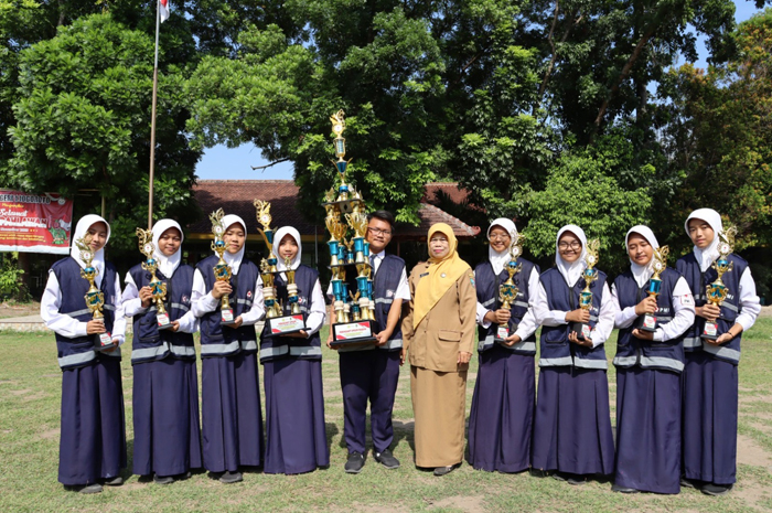 Tim PMR bersama trofi juara umum dan trofi masing-masing siswa disampingi kepala SMPN 1 Jogoroto Jombang