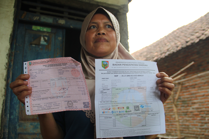 warga Desa Mojotrisno, Kecamatan Mojoagung menunjukkan SPPT di rumahnya.  Tahun 2024, mereka mengeluhkan naiknya tagihan PBB yang mencapai lebih dari 5 kali lipat.