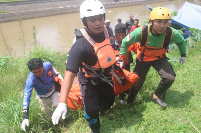 Proses evakuasi jasad Alvian Andi Wahyudi, pemuda yang tenggelam di Bendung Balongsono, Desa Talunkidul, kecamatan Sumobito, Jombang.