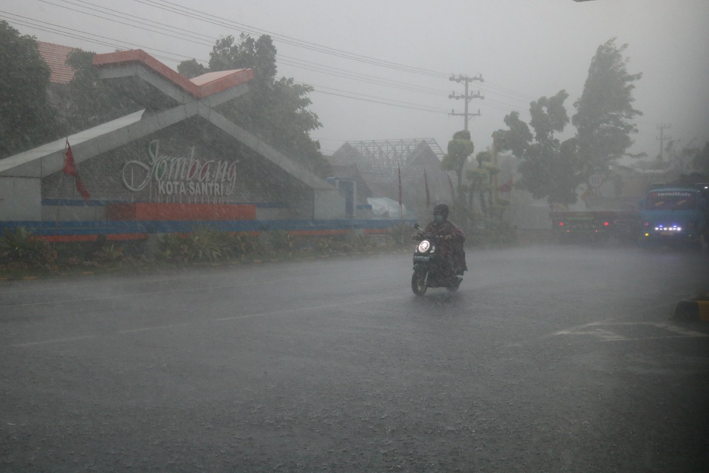 Seorang pengendara sepeda motor menerjang hujan deras dan angin kencang di Jl Provinsi Jombang-Ploso Pesantren, Kecamatan Tembelang