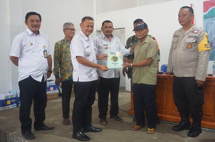 Kepala Desa Tunggorono Didik Dwi Mulyawan menyerahkan sertifikat PTSL kepada para warganya di gedung serbaguna, Tunggorono