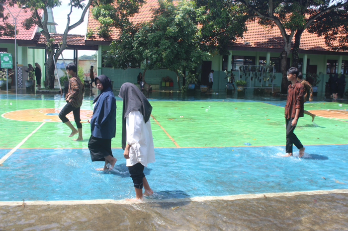 BANJIR: Air menggenang hingga setinggi mata kaki di halaman SMPN 2 Gudo, Jumat (2/2).