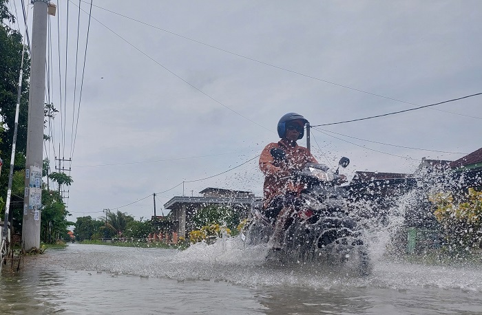 Banjir luberan Kali Marmoyo di Desa Gedongombo Rabu (8/2) menggenangi jalan dan mengganggu aktivitas warga.