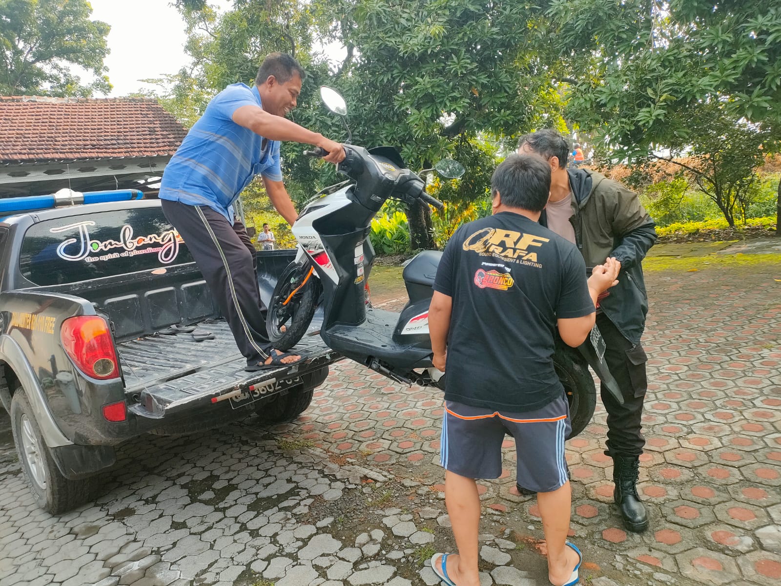 Petugas kepolisian saat mengamankan sepeda motor milik pemuda Jombang yang menceburkan diri ke sungai brantas
