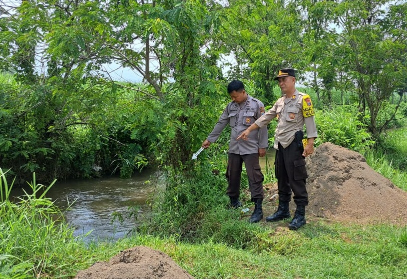 Petugas kepolisian saat melakukan olah kejadian perkara di sungai tempat korban ditemukan tewas dan hanyut
