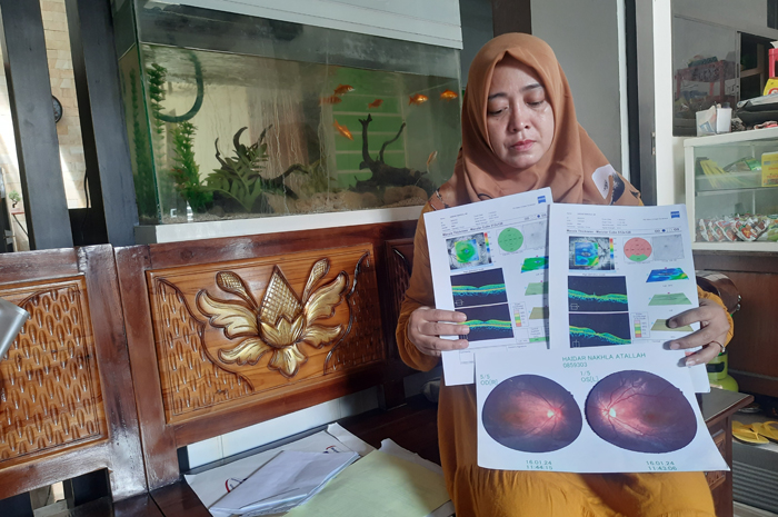 Erna menunjukkan hasil pemeriksaan mata ID akibat terlempar kayu di lingkup sekolah.