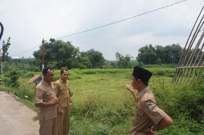 LEBIH BERMANFAAT: Kepala Desa Ngrimbi Samsul Hadi (mengenakan kopyah hitam) menunjukkan lokasi TKD yang akan dijadikan rest area.