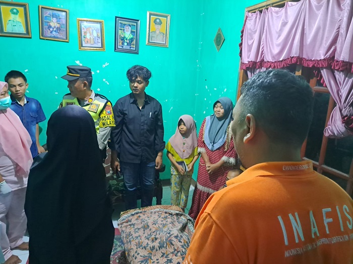 Petugas kepolisian saat melakukan pemeriksaan pada jasad balita yang hanyut di saluran air