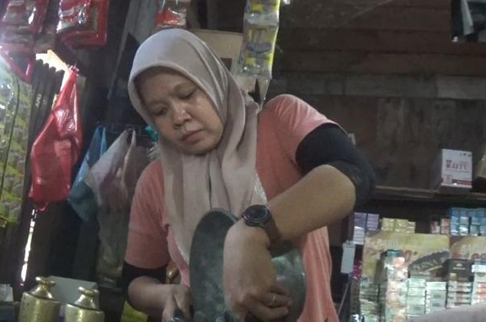 MASIH TINGGI: Salah satu pedagang di Pasar Pon menimbang beras yang dijual, Senin (26/2).