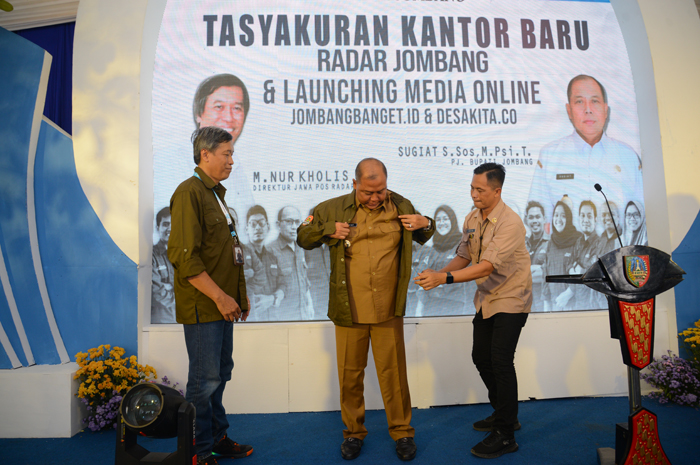 Pj Bupati Jombang Sugiat mengenakan seragam setelah mendapat apresiasi sebagai Redaktur Kehormatan Jawa Pos Radar Jombang.
