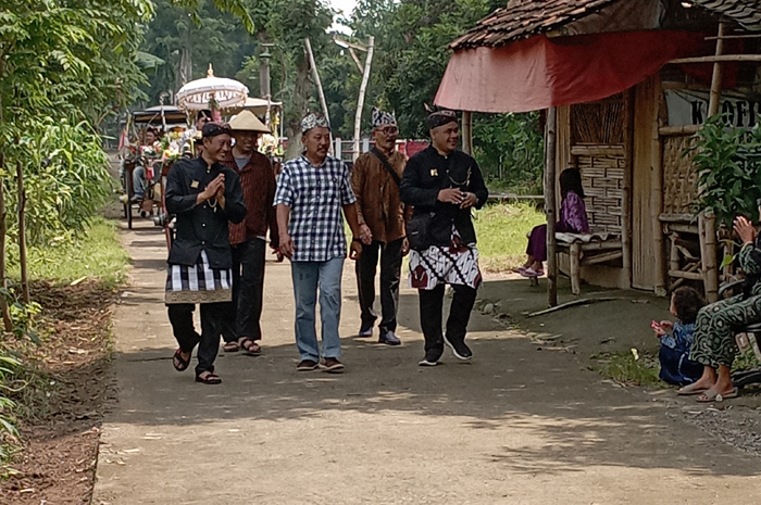 Kepala Desa Miagan Antok Budi Subagyo (paling kiri) menyapa warga saat pawai budaya kirab tumpeng hasil bumi mengelilingi desa.