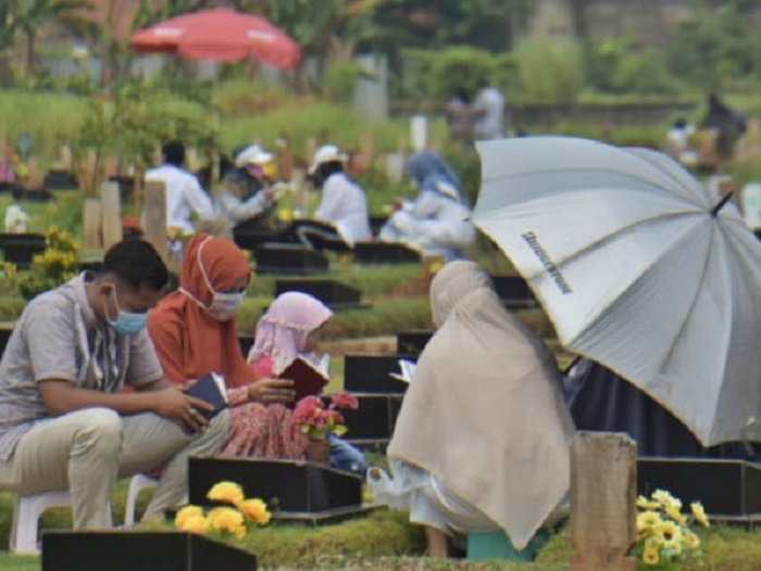 Foto&nbsp;beberapa orang ziarah kubur&nbsp;ke makam keluarga