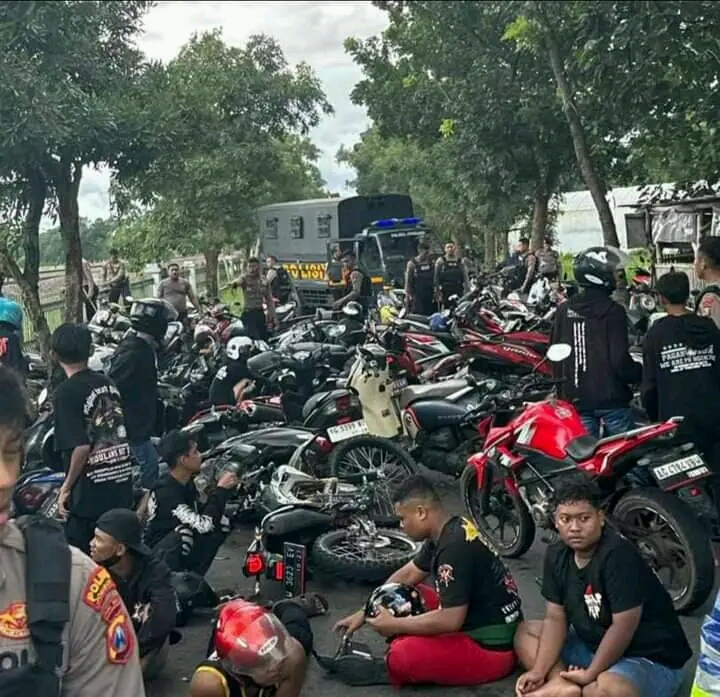 Petugas saat menghentikan aksi konvoi dan geber-geber dan mengaggu jalan yang dilakukan ratusan anggota perguruan silat di Jombang