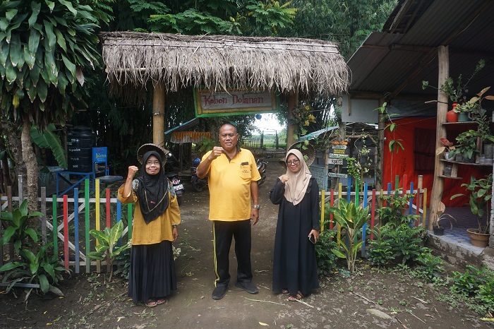 Kepala Desa Pulorejo Kop Mustoko (tengah) didampingi pengurus BUMDes Subur Makmur saat berada di depan gerbang masuk Kebon Dolanan.