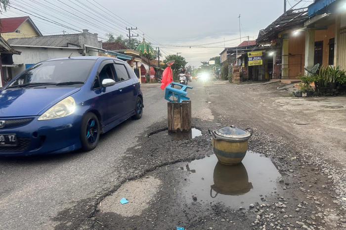 BIKIN CELAKA: Lubang jalan di Desa Menganto, Kecamatan Jogoroto, Jombang bikin celaka pengendara dipasang tanda ban bekas.