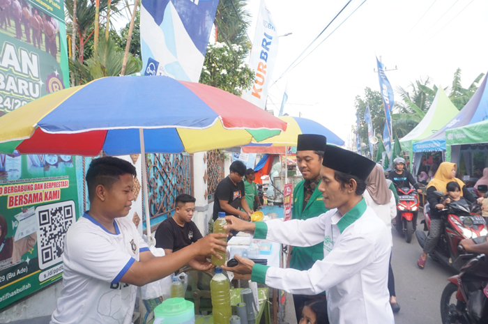 Kepala Desa Tambakrejo Mohammad Nasir Fadlillah (baju putih) membeli produk dari pedagang di pasar Ramadan.