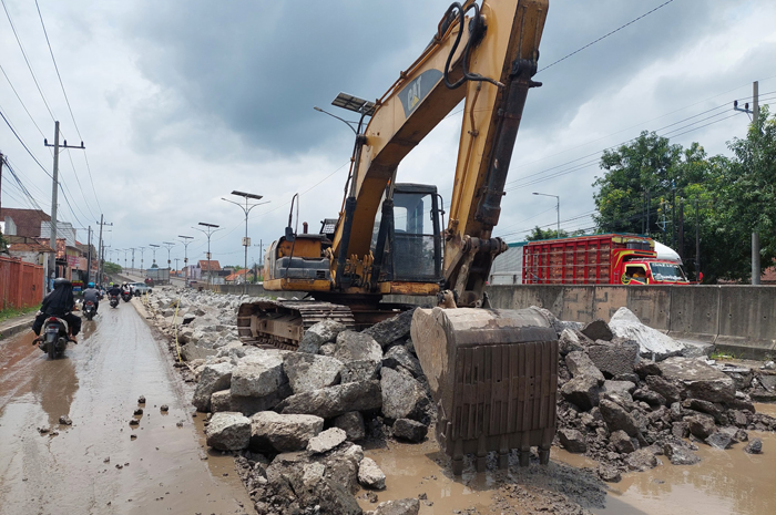 Alat berat sedang membongkar cor jalan nasional di Peterongan Jombang