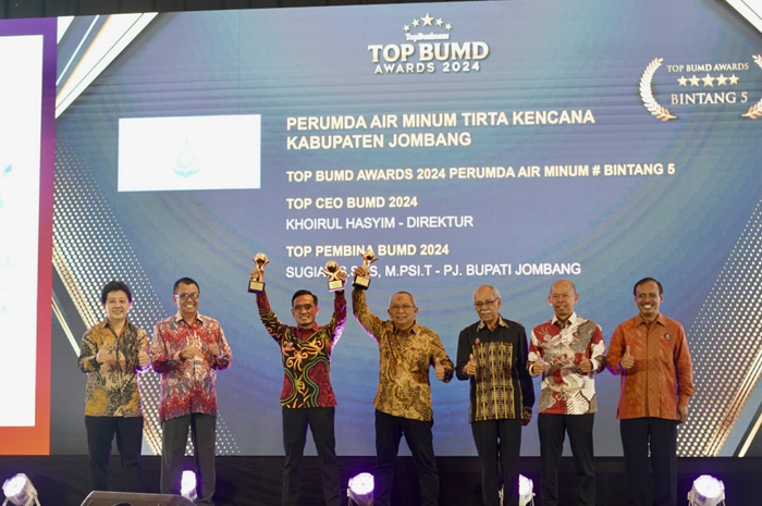 Direktur Perumdam Tirta Kencana Jombang, Khoirul Hasyim (tiga dari kiri), bersama Asisten Perekonomian dan Pembangunan Setdakab Jombang, Wignyo Handoko (empat dari kiri), mengangkat trofi penghargaan