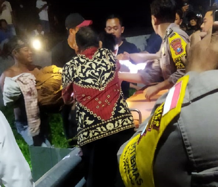 Petugas kepolisian bersama warga saat mengevakuasi jasad santri asal Jakarta yang tersambar kereta api di Jombang