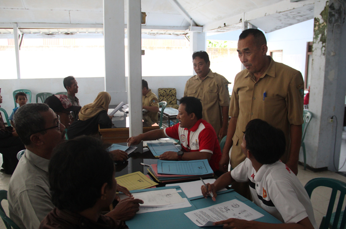 Kepala Desa Keplaksari Agus Sudarto mendampingi panitia saat pendaftaran PTSL