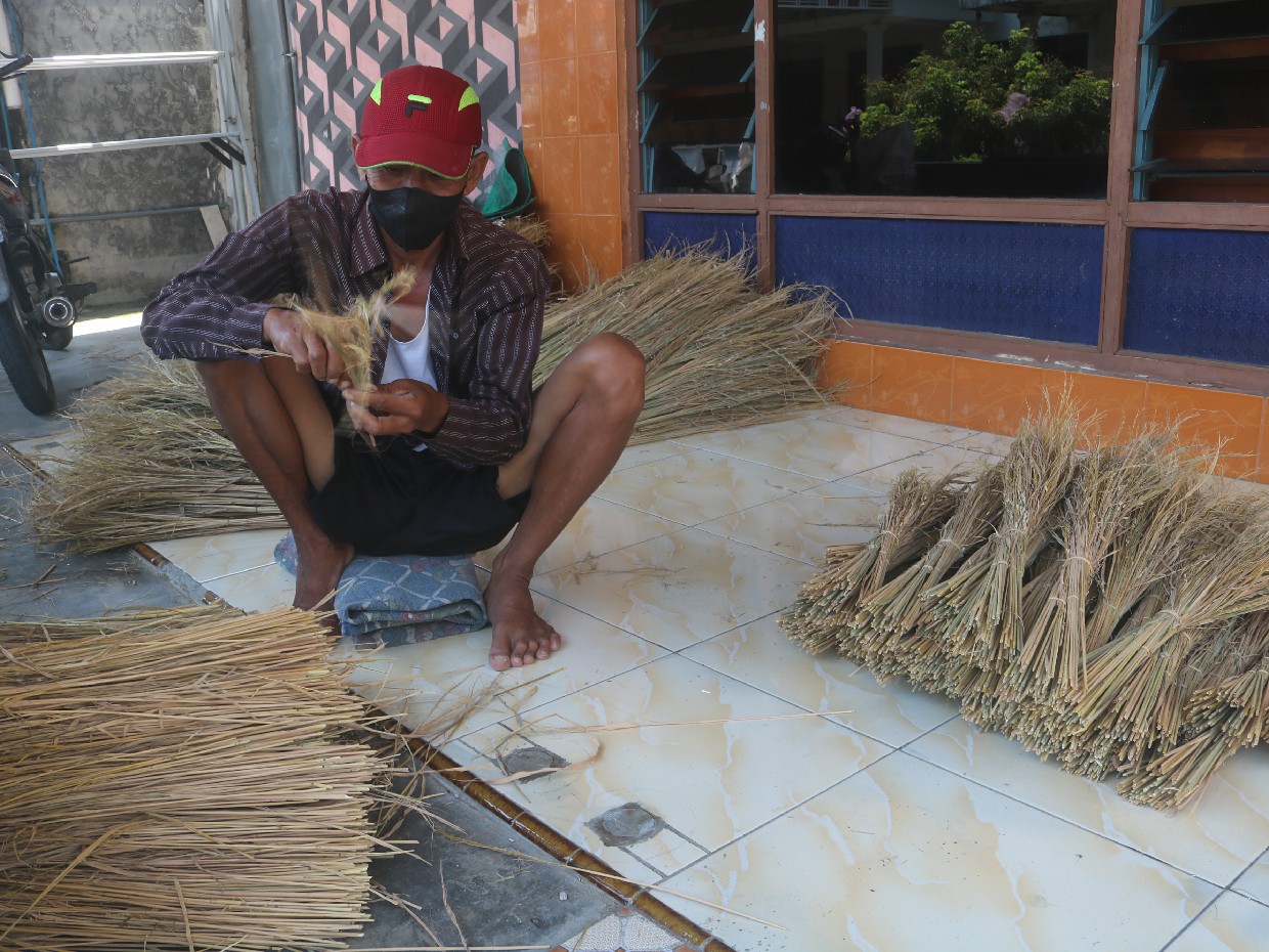 Sabar, warga Gabusbanaran, Kecamatan Tembelang, Jombang sedang membuat kerajinan merang untuk kebutuhan sesajen di rumahnya.