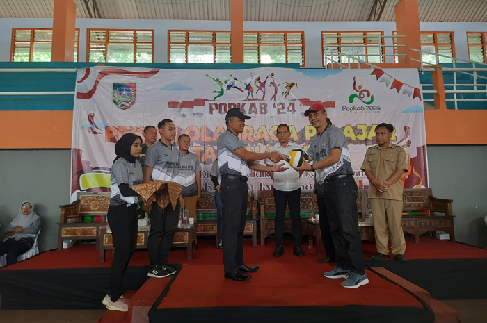 JUNJUNG TINGGI SPORTIFITAS: Kepala Dinas P dan K, Senen, menyerahkan bola voli secara simbolis kepada Abdul Gofur sebagai tanda Popkab dimulai di GOR Merdeka Jombang, Senin (22/4).