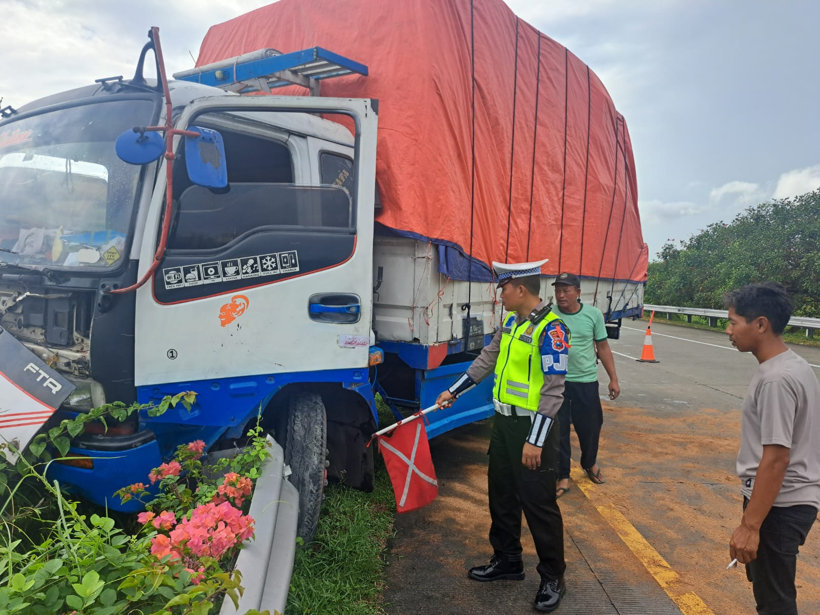 Polisi saat mengevakuasi truk yang menabrak guardrail Tol Jombang Mojokerto Kamis (25/4) pagi.