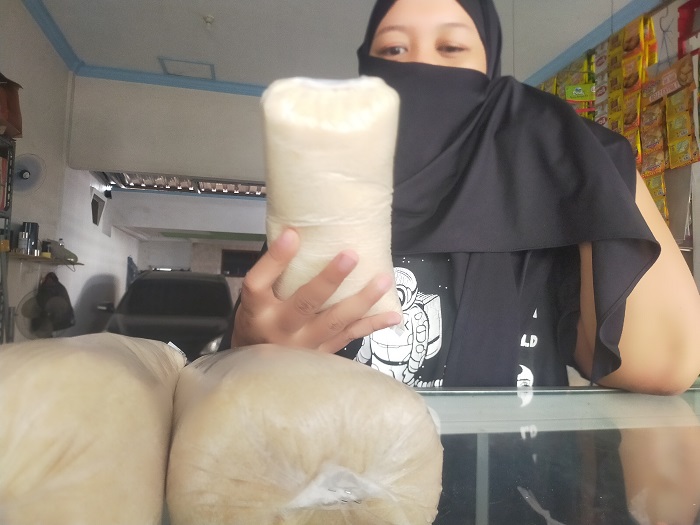 NAIK: Salah seorang pedagang PCN Jombang menunjukkan gula pasir yang dijual merangkak naik.