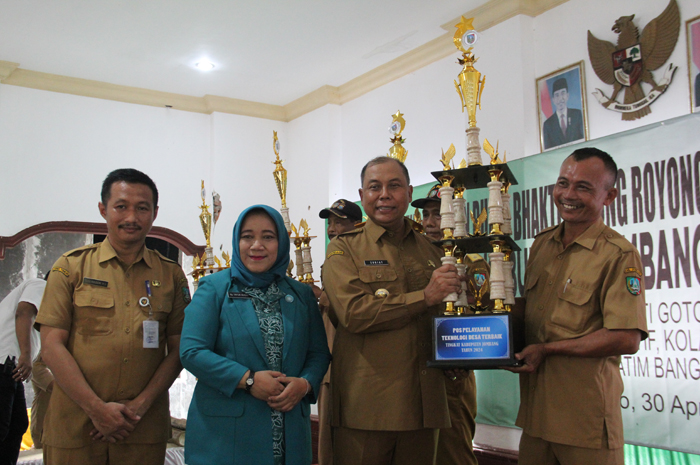 Kepala Desa Jatiduwur Subardi menerima piala juara lomba posyantekdes dari Pj Bupati Jombang didampingi Kepala DPMD Jombang.