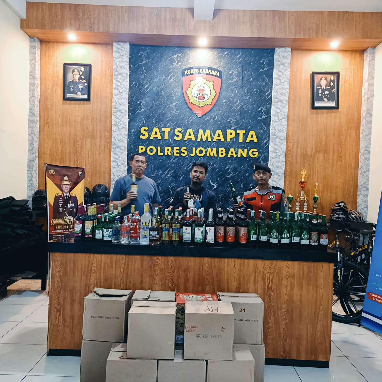 Polisi menunjukkan bukti ratusan botol miras yang disita dari sebuah rumah di Ngoro,. Jombang