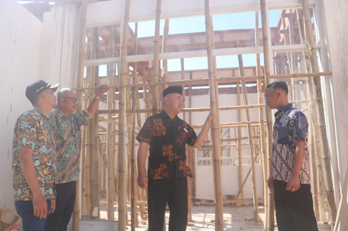 Kades Gumulan Busroni (Tengah) bersama perangkat desa meninjau progres pembangunan ruangan baru untuk kantor desa Gumulan