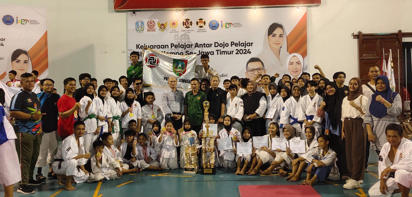 MEMBANGGAKAN: Wakil Ketua Perkemi Jombang, Dear Satriya Dzikria (kiri), Ketua KONI Jombang, Sumarsono (tiga dari kiri) menerima trofi juara umum kejuaraan pelajar se-Jatim piala bergilir Kadispora Jat