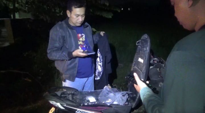 Polisi saat mengamankan sepeda motor yang ditemukan warga tergeletak di semak-semak Desa Kebontemu, Jombang