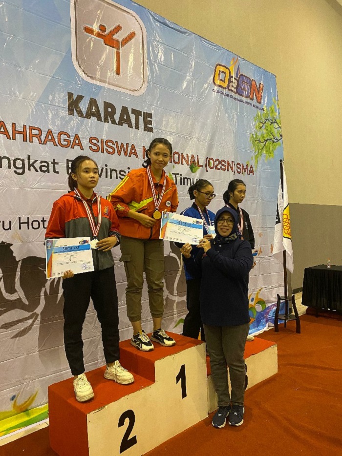 Salsabila Putri dari SMAN 2 Jombang menerima trofi dan piagam juara 1 kumite O2SN SMA Jatim di Batu, kemarin.