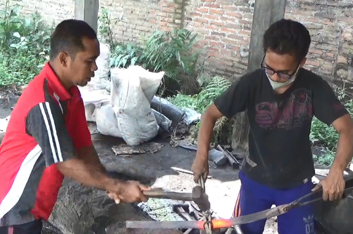 Perajin golok di Desa Tambar, Kecamatan Jogoroto Jombang tengah membuat pesana golok. Jelang idul adha, pesanan golok yang datang ke mereka tak terbendung